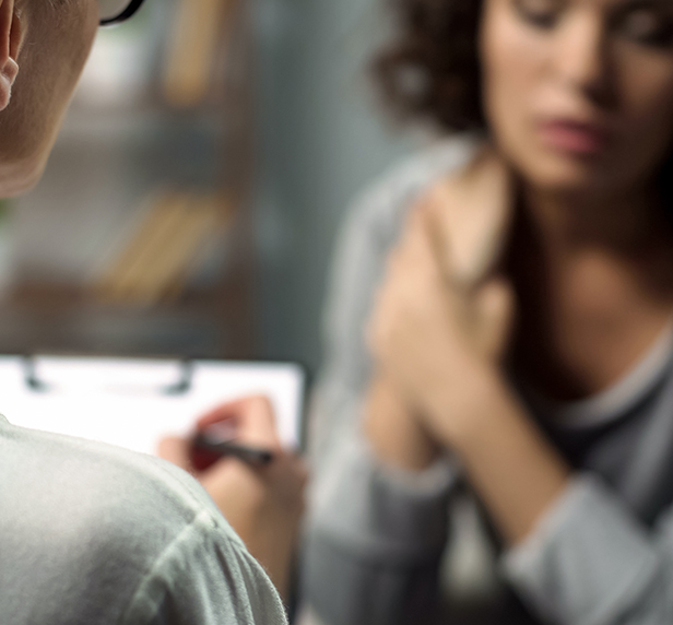 A woman looks concerned while telling her therapist about Dysthymia