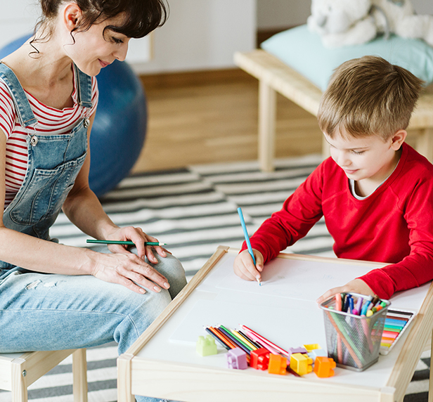 A therapist and a child with autism have a creative therapy session.
