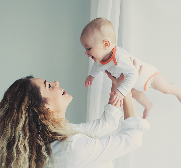 A woman happy with her baby after treating her postpartum depression.